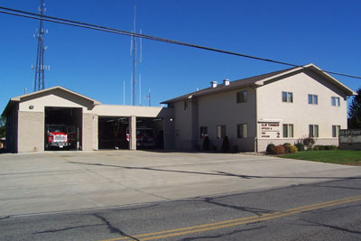Gray building housing 2 fire trucks